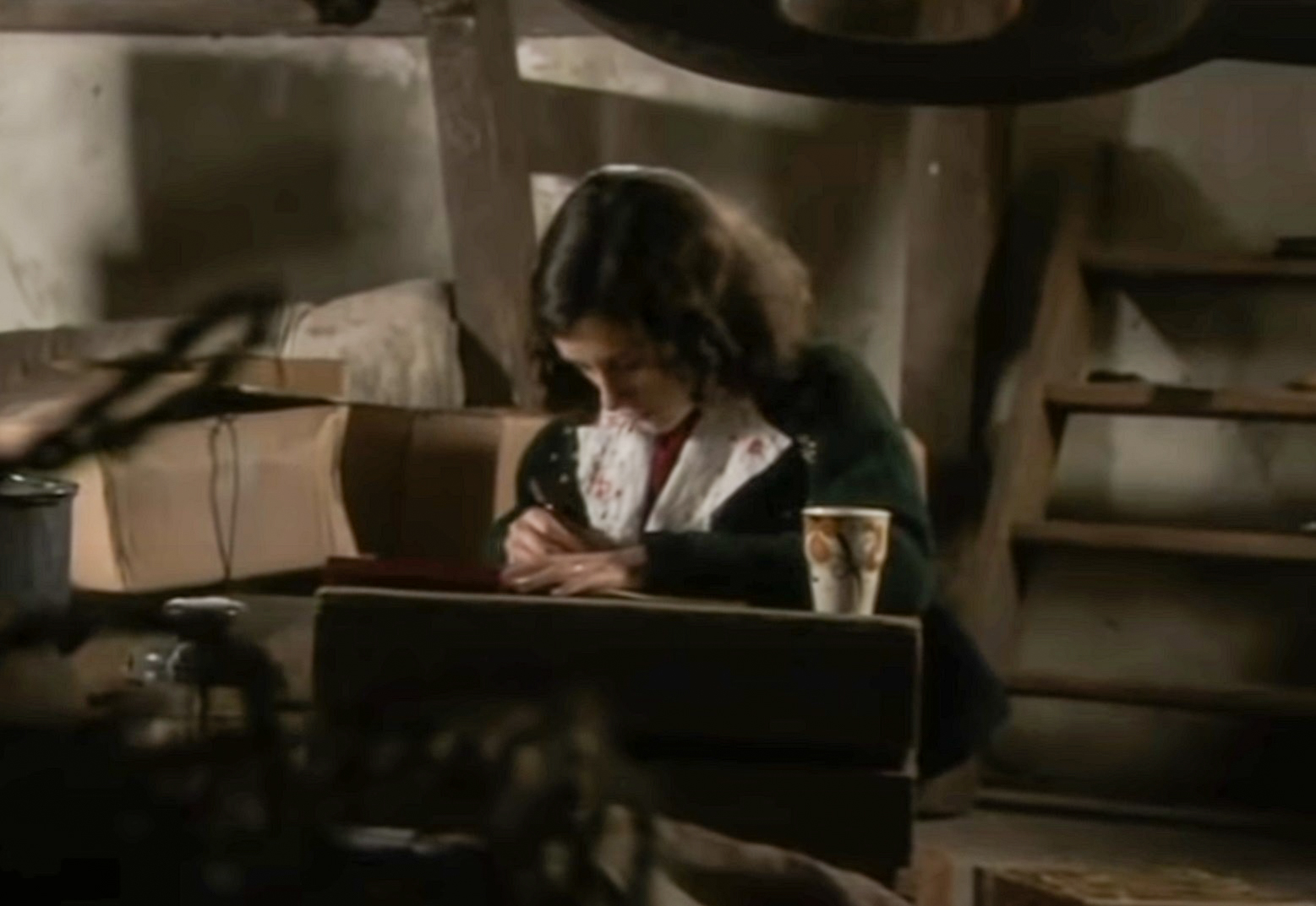 Screenshot: (Ellie Kendrick) Anne Frank with long hair looking down at her diary - From BBC ,The Diary Of Anne Frank (2009)