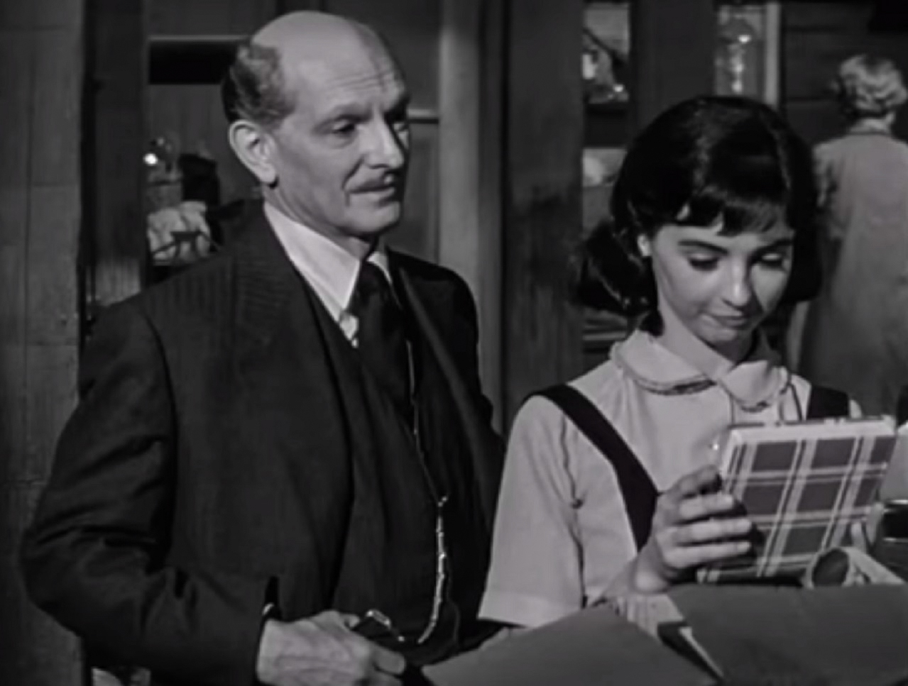 Screenshot: B&W photo (Millie Perkins) Anne Frank looking at diary - From The Diary Of Anne Frank (1959)