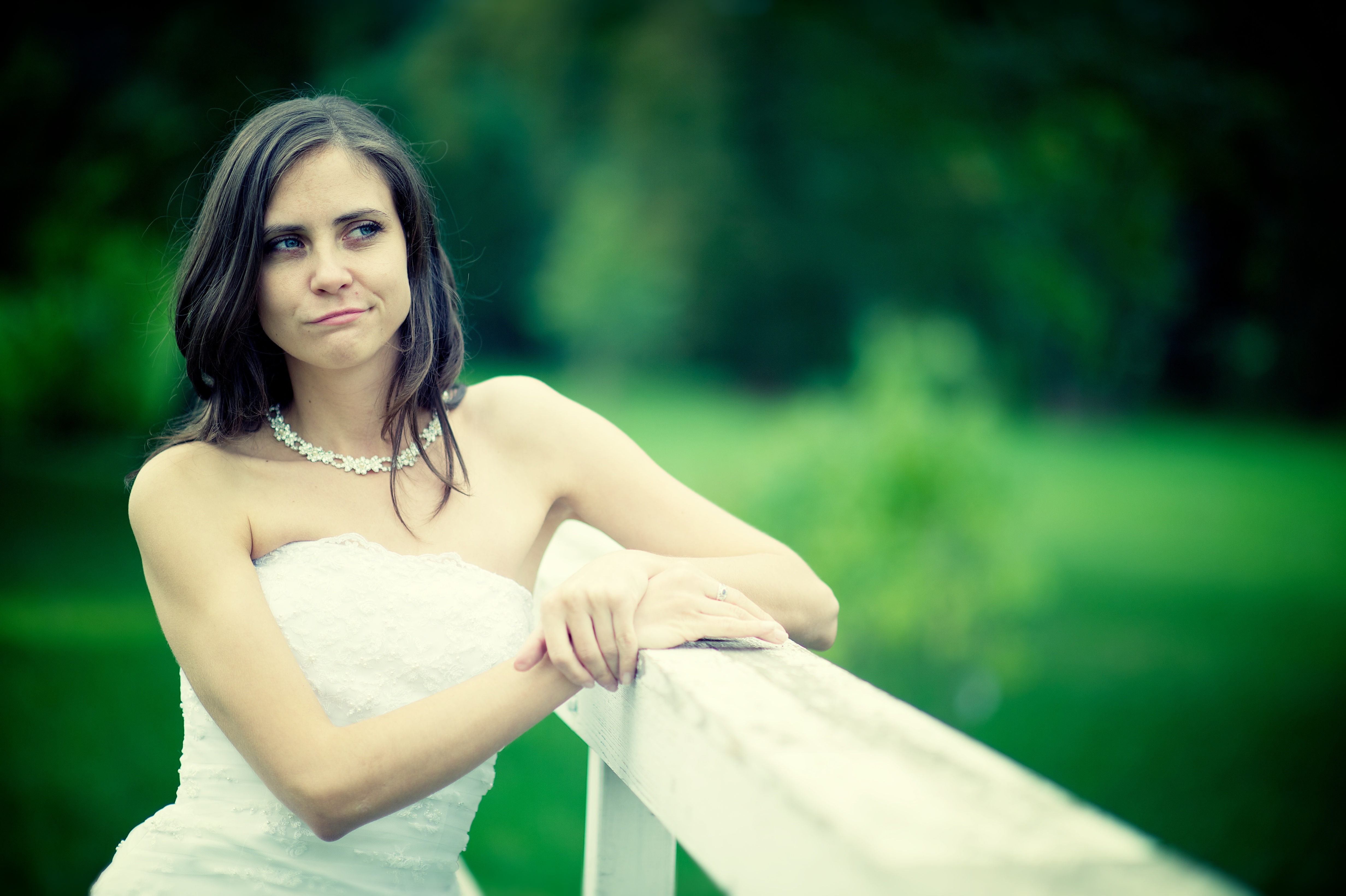 Young bride in wedding dress looking disinterested.