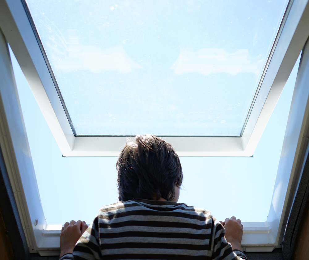 Kid in striped t shirt climbing on the roof