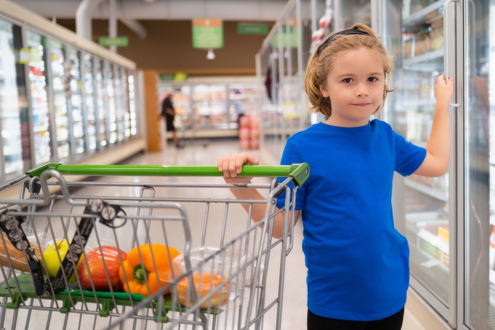 Child in blue t-shirt  buying fruit in supermarket