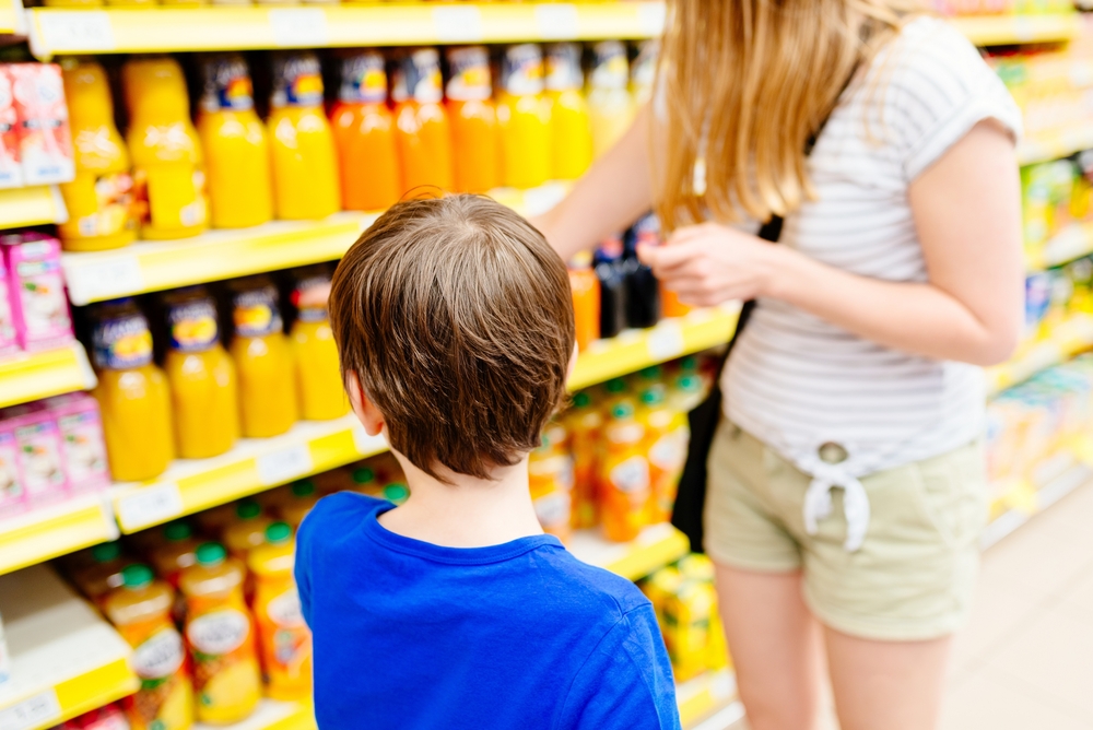 Child in blue t-shirt and his mother choosing food