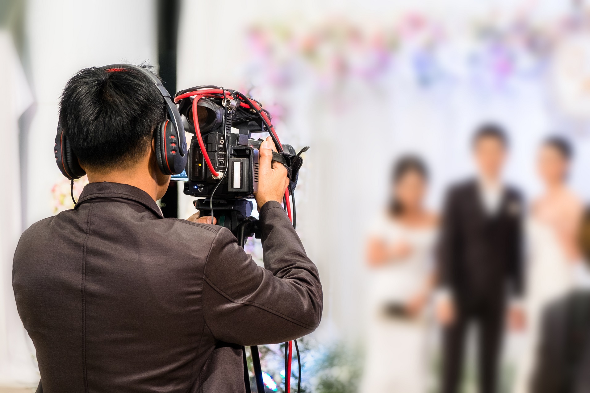 Videographer recording wedding ceremony.