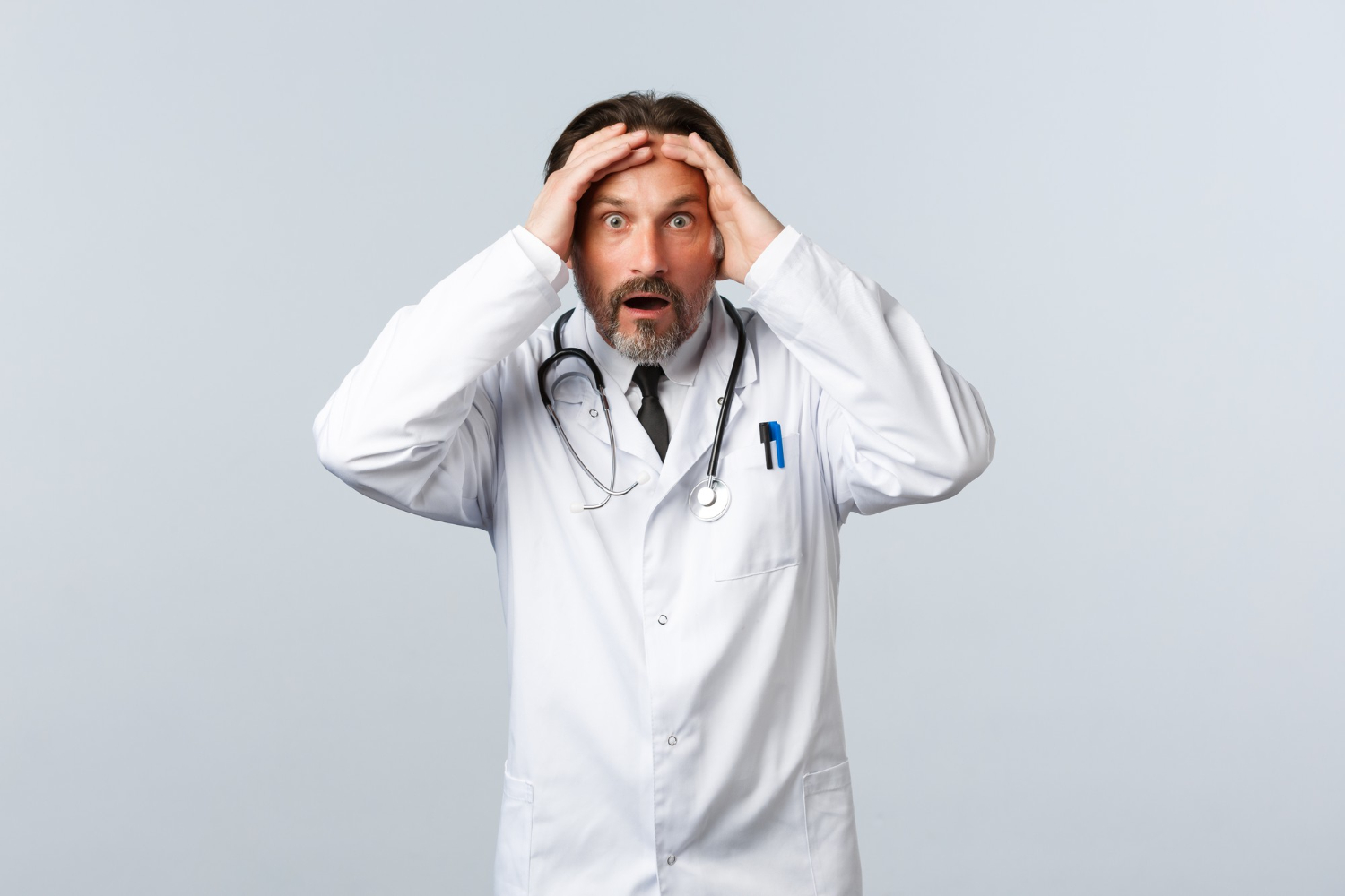 Shocked male doctor is holding his head.