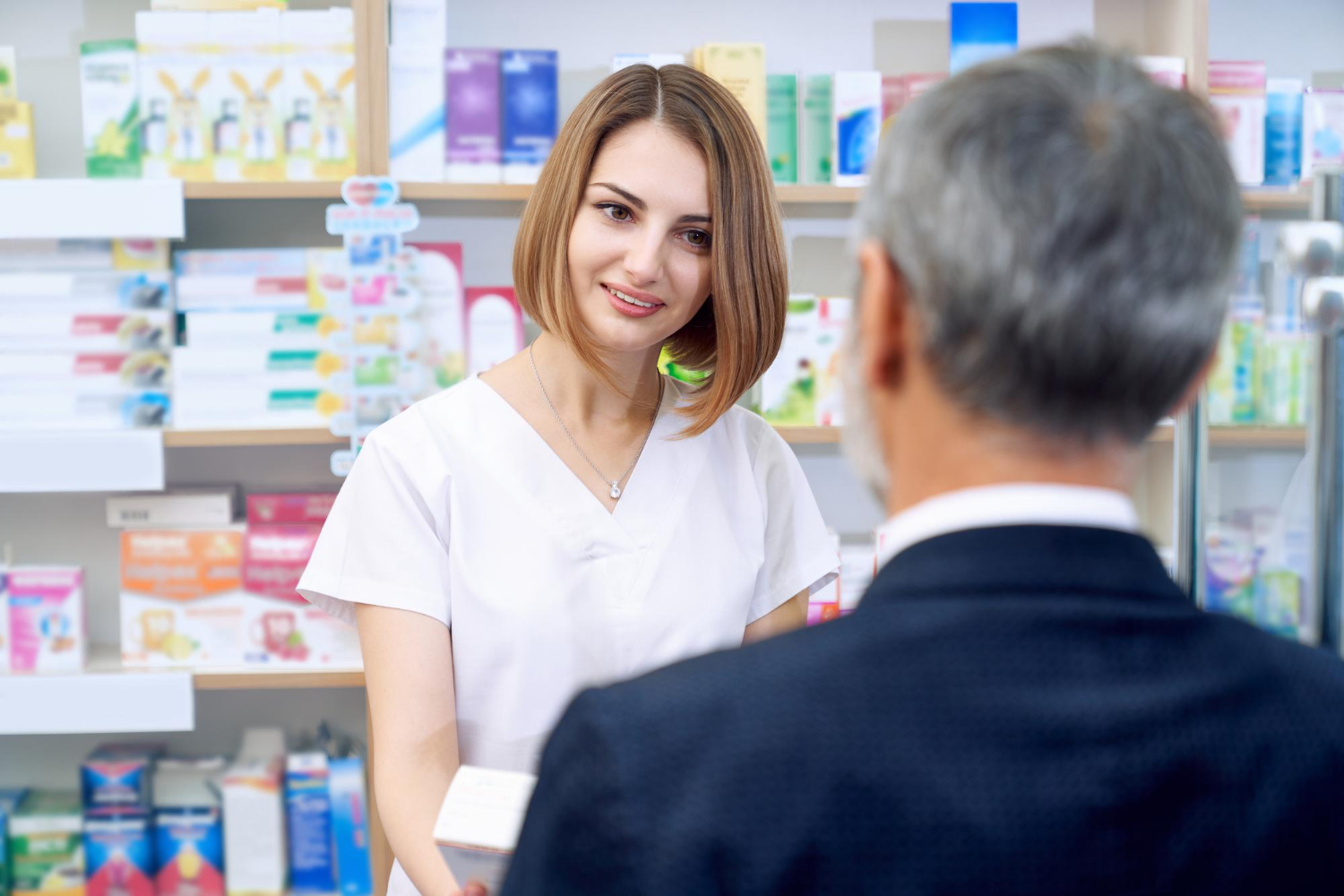 Pharmacist is consulting customer in drugstore.