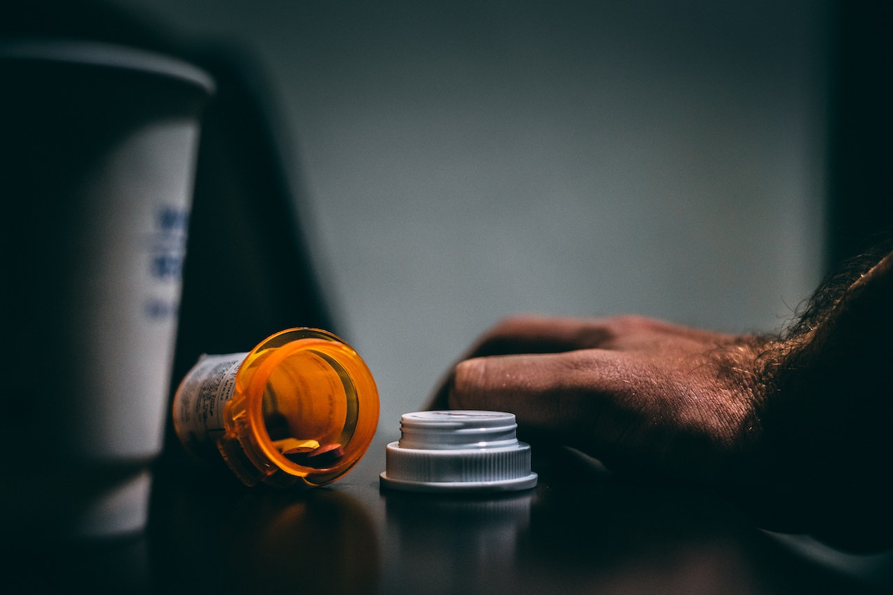 Prescription bottle with pills on the table.