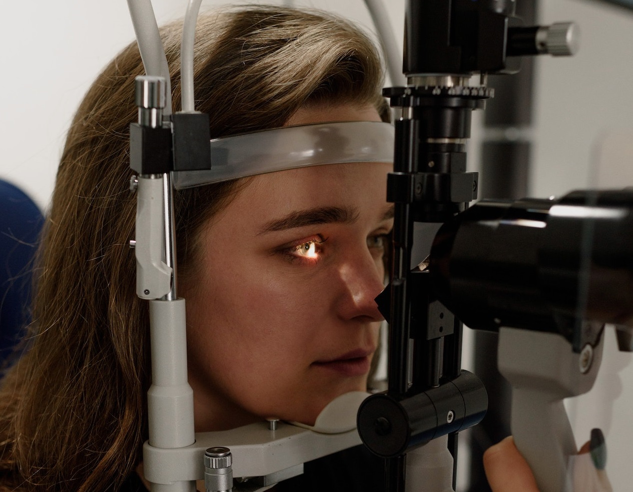 Woman is checking her eyes at optometrist.