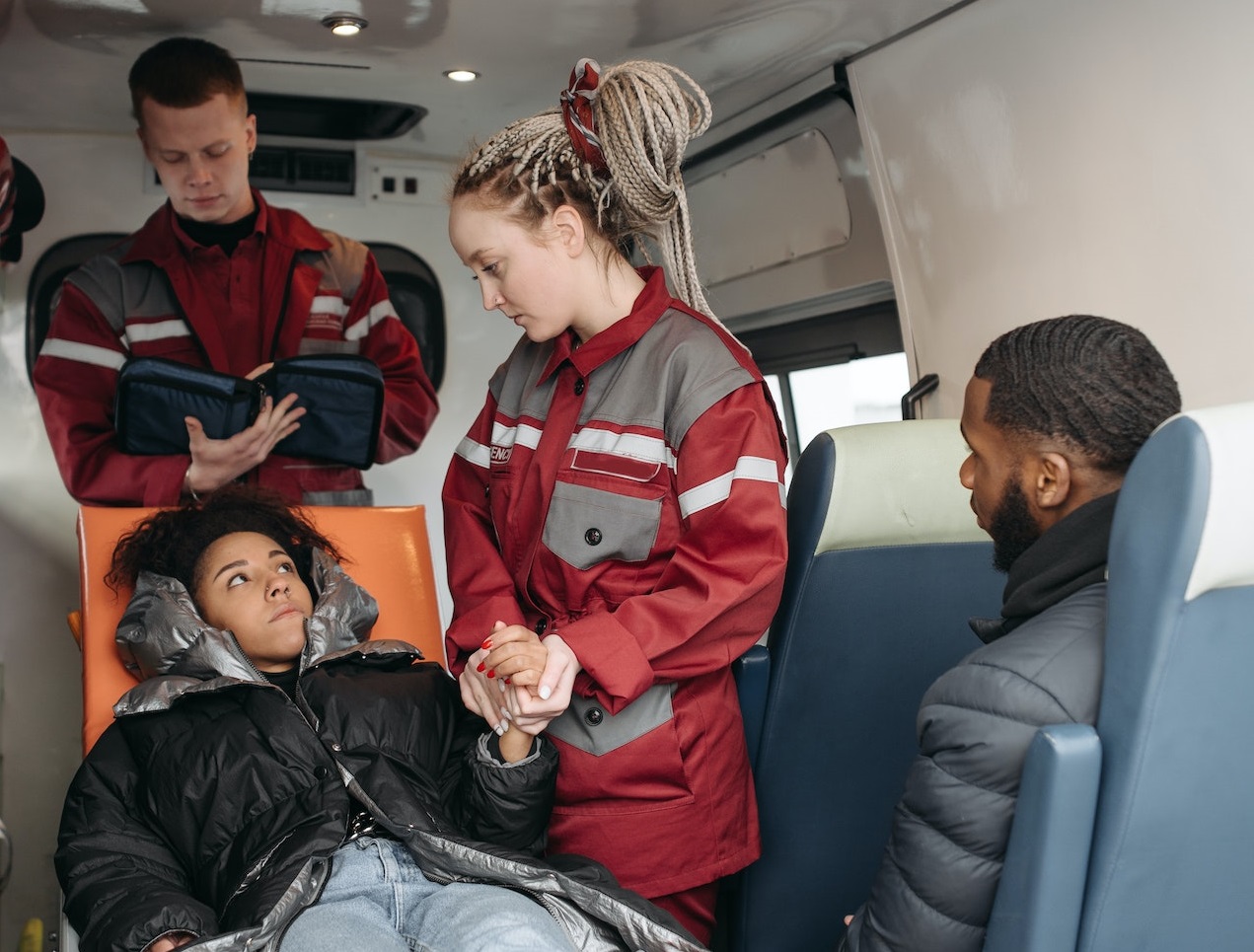 Woman is laying in back of a paramedic van.