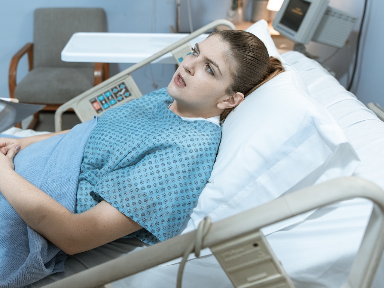 Woman is laying in hospital bed.