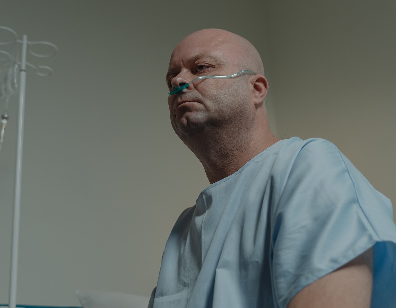 Man is seating on hospital bed.