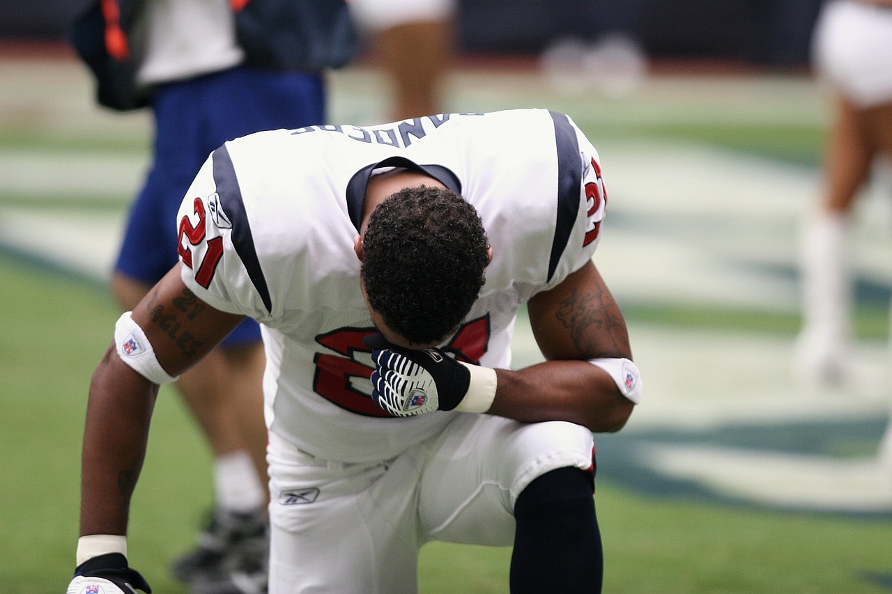 Professional American football player sitting on his knee