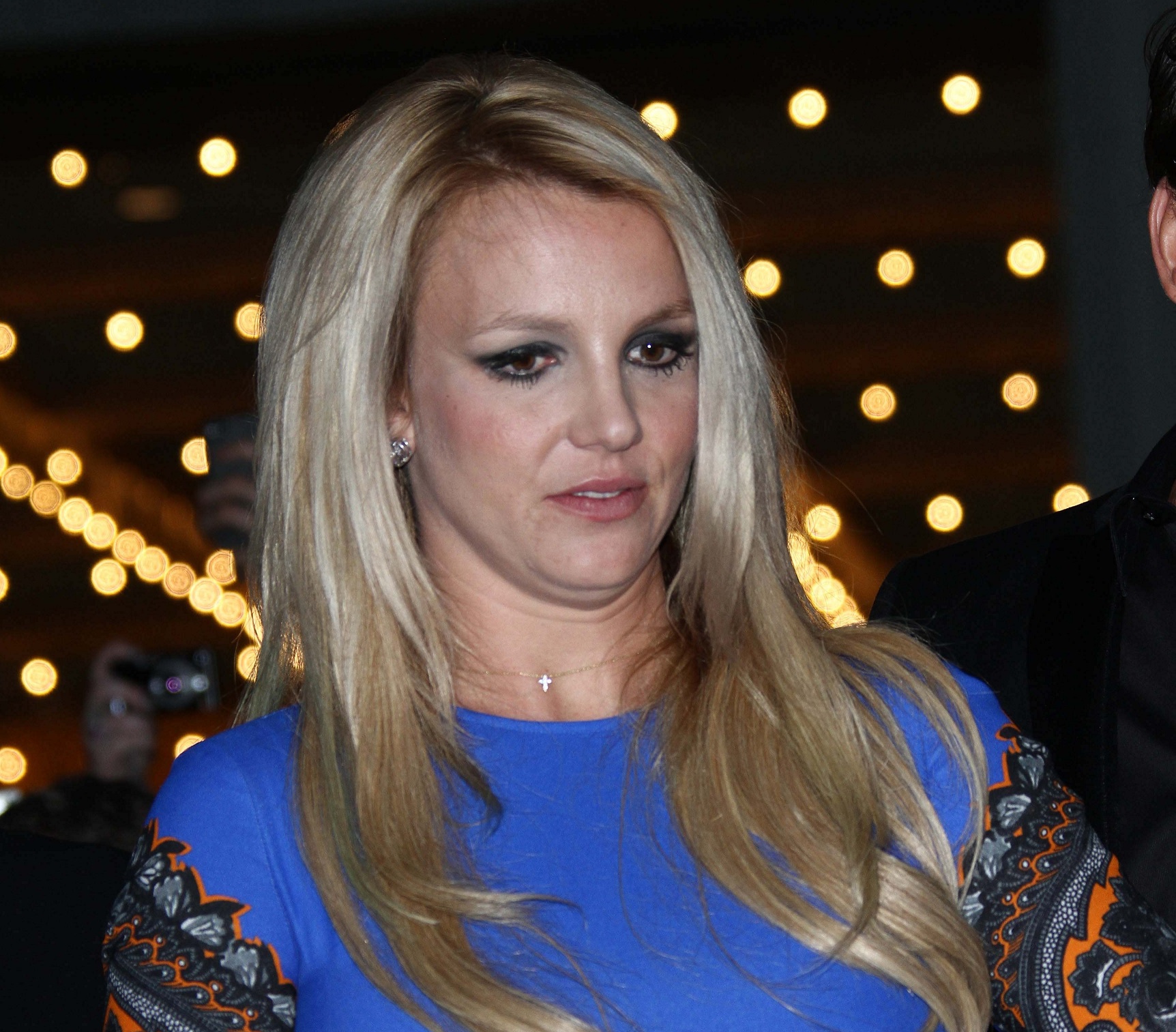 Britney Spears wearing blue dress is looking at side with sad face - 2012