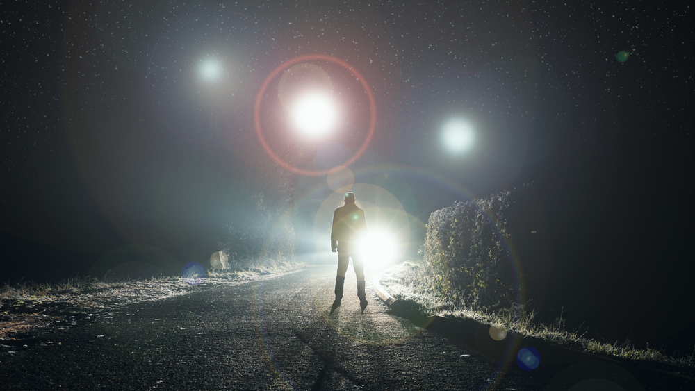 Glowing orbs, floating above a misty road at night