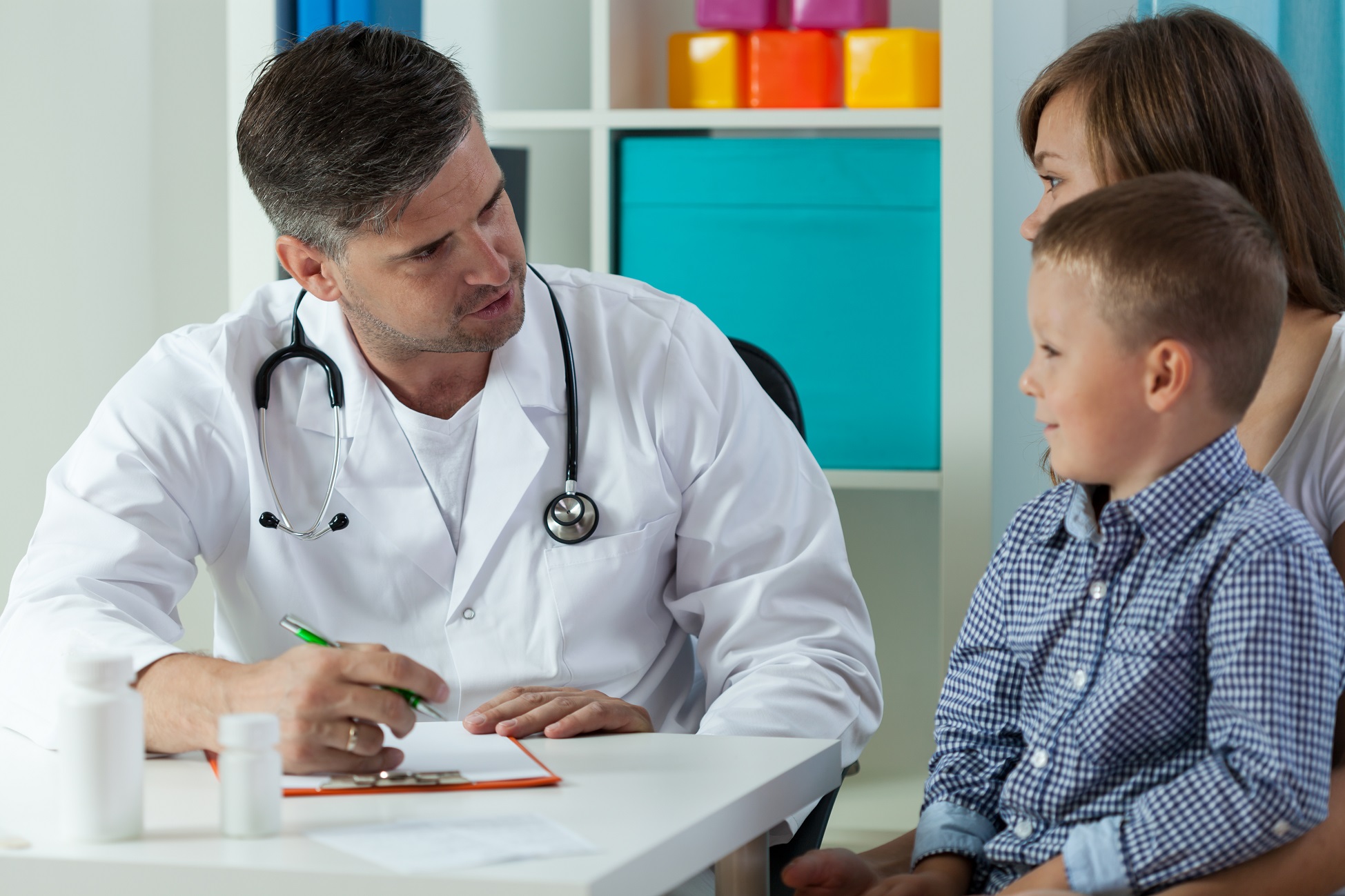Little boy with mum talking with the male doctor.