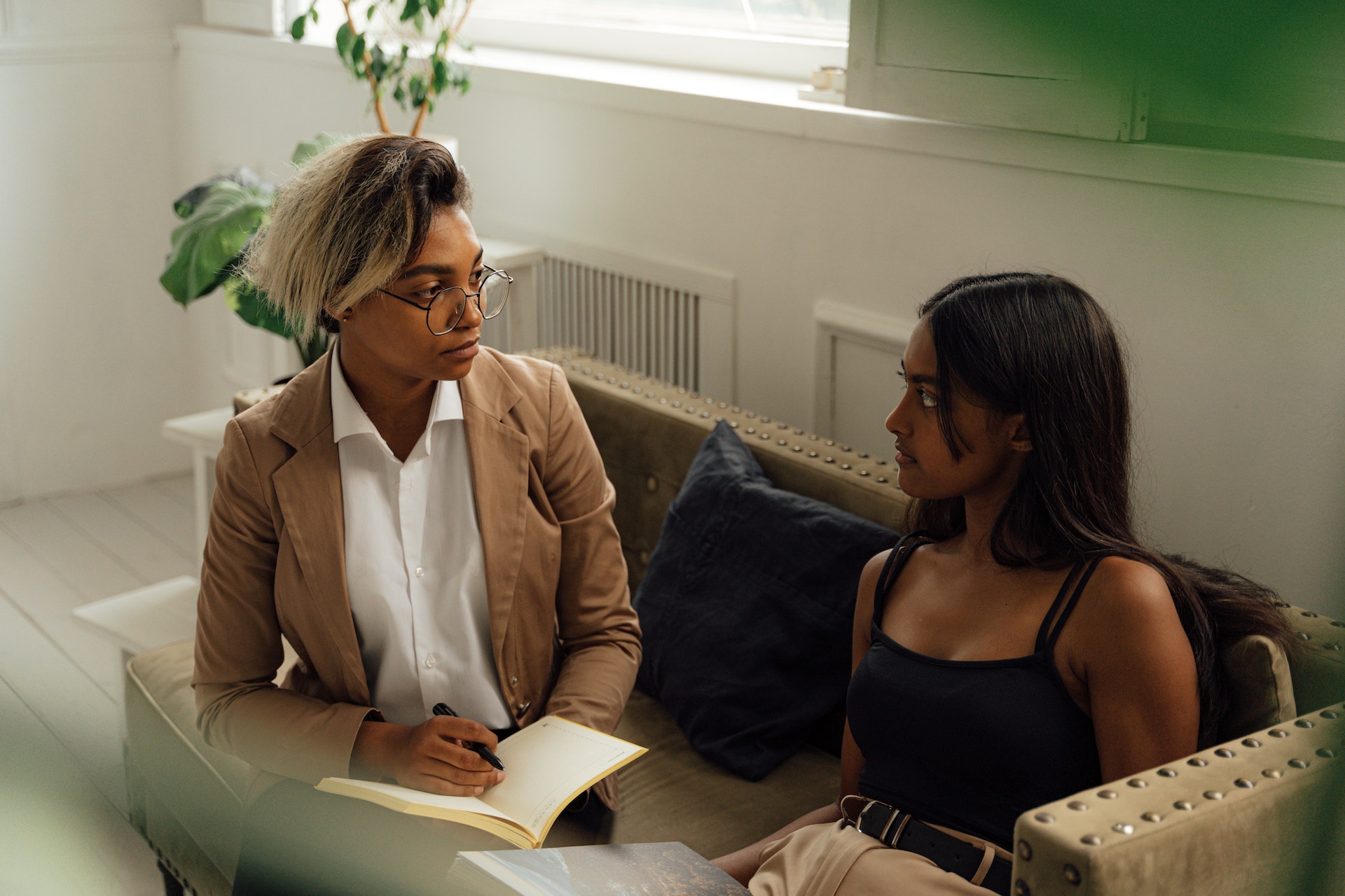 Student and female teacher are having conversation in her office.
