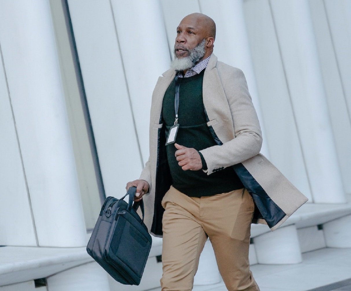 Man is holding a briefcase and running on the street.