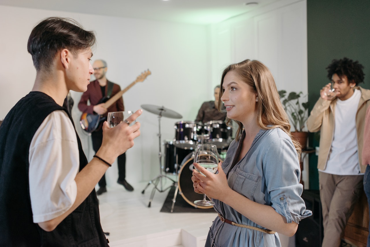Young man is talking with a girl in blue dress at party,