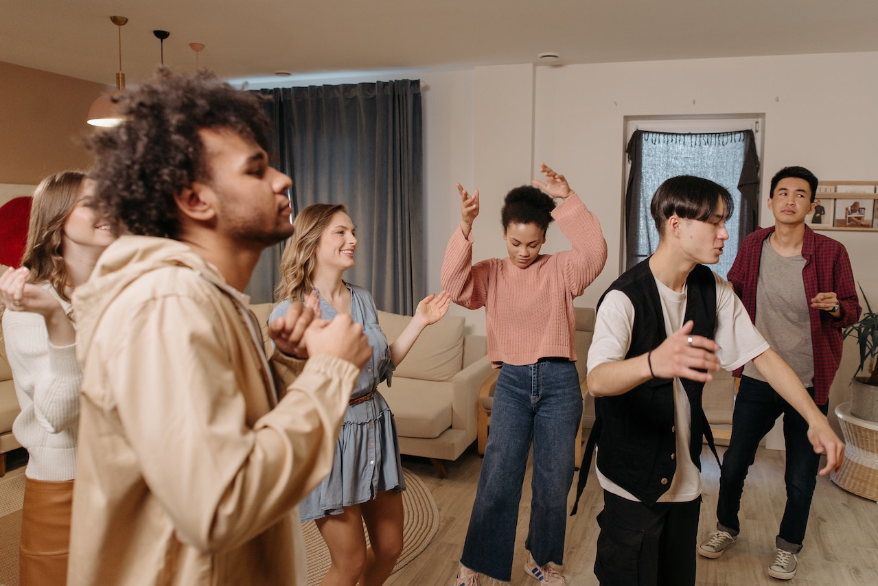 Young people are dancing inside a room.
