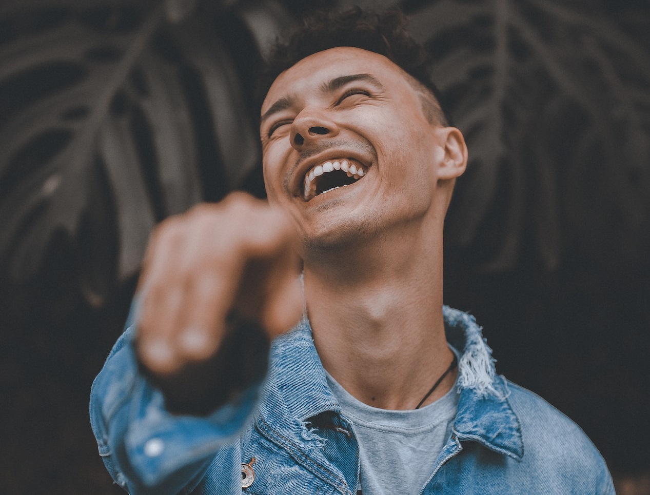 Young man is smiling and pointing with hand.