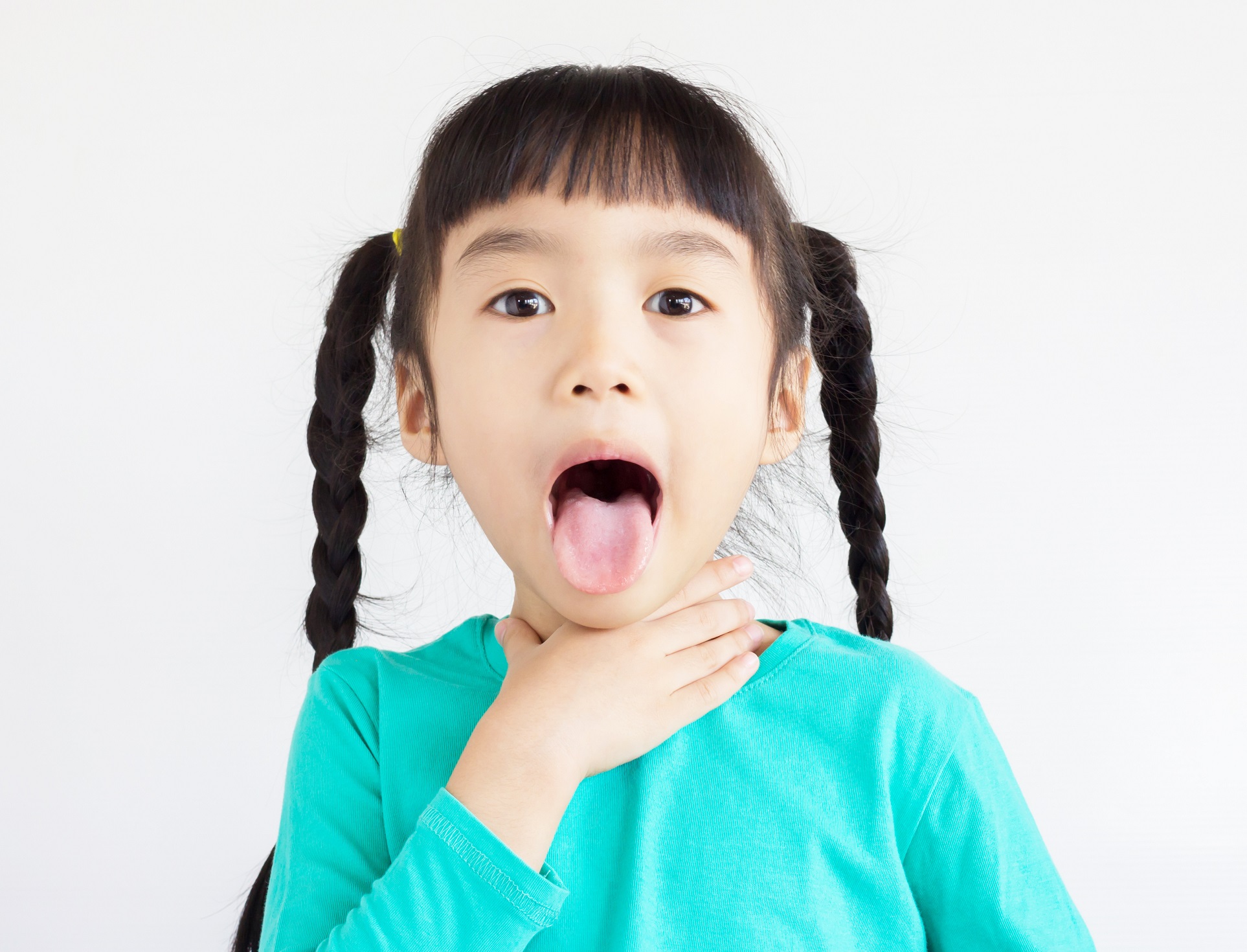Small girl is choking on food and looking at camera.