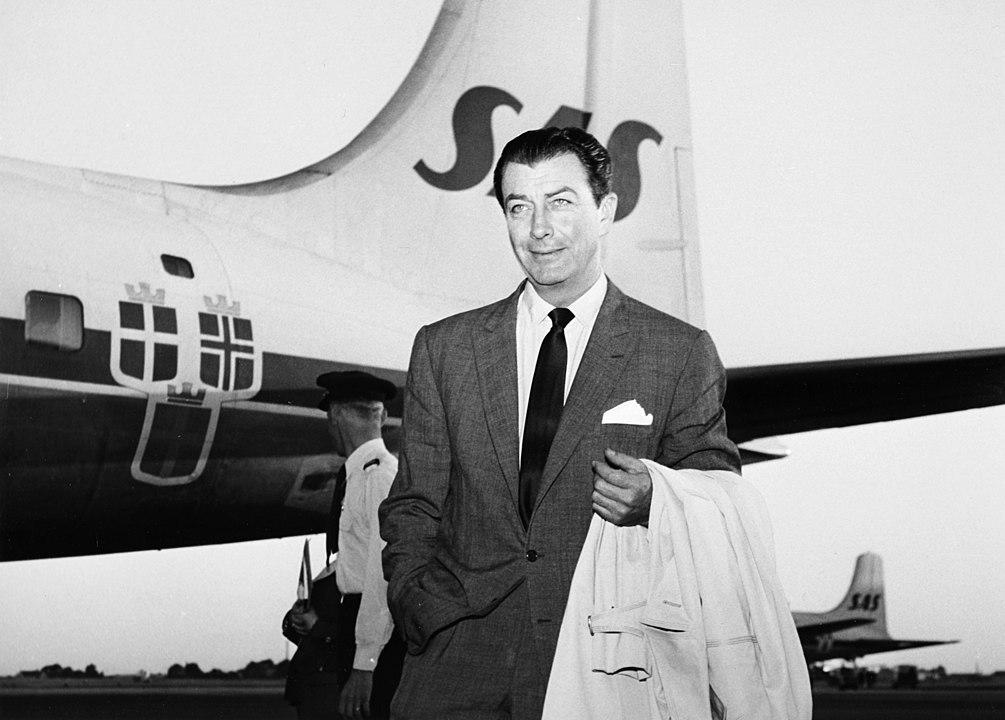 Robert Taylor, actor, USA. 1957-06-25 in suit at an airport