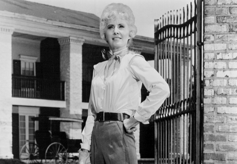 Barbara Stanwyck Big Valley in front of a house