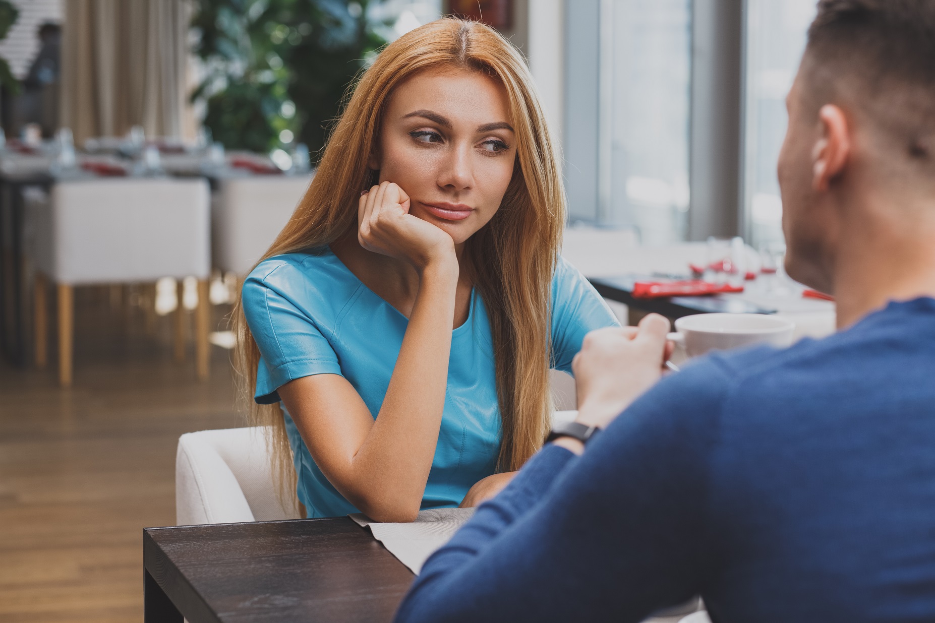 Young woman is looking sad seating on a table.