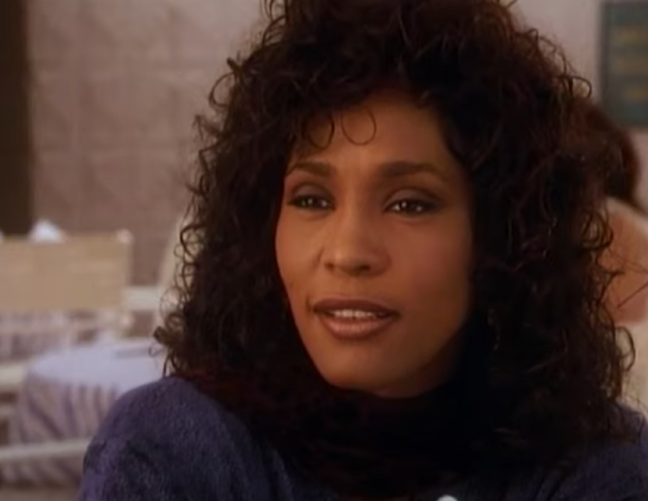 Screenshot of Whitney Houston is looking at side and smiling - from Waiting to Exhale (1995)