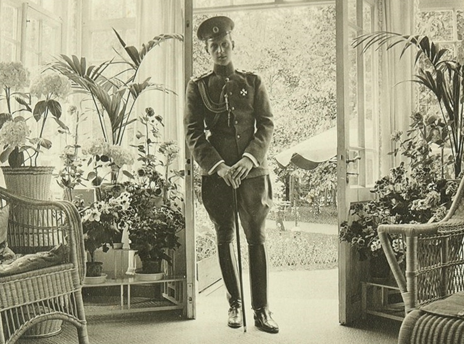 Grand Duke Mikhail Alexandrovich Romanov wearing military uniform is standing in room and watching at camera - circa 1912 - 1914
