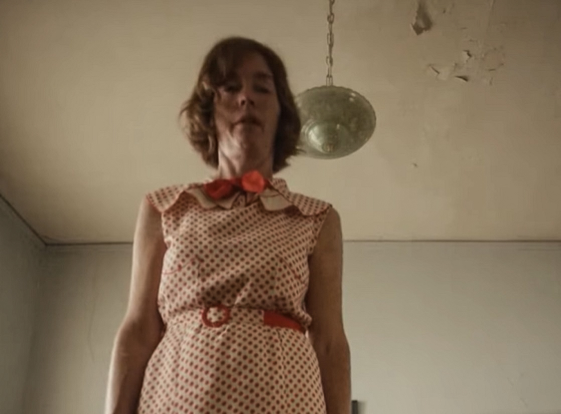Screenshot: Gladys Pearl Baker (Julianne Nicholson) is looking down,standing in old room - from Blonde (2022)