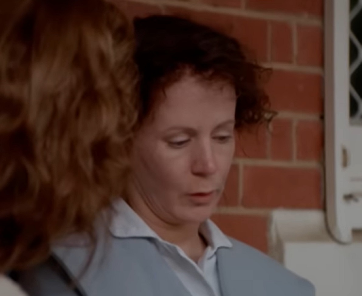 Screenshot: Gladys Pearl Baker (Patricia Richardson) is seating outside , looking down - from Blonde (2001)