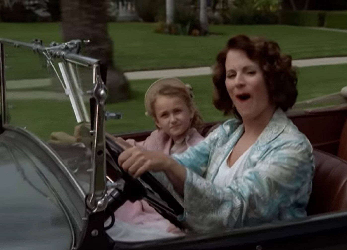 Screenshot: Gladys Pearl Baker (Patricia Richardson) is driving inside a car with young girl (Marilyn Monroe) - from Blonde (2001)