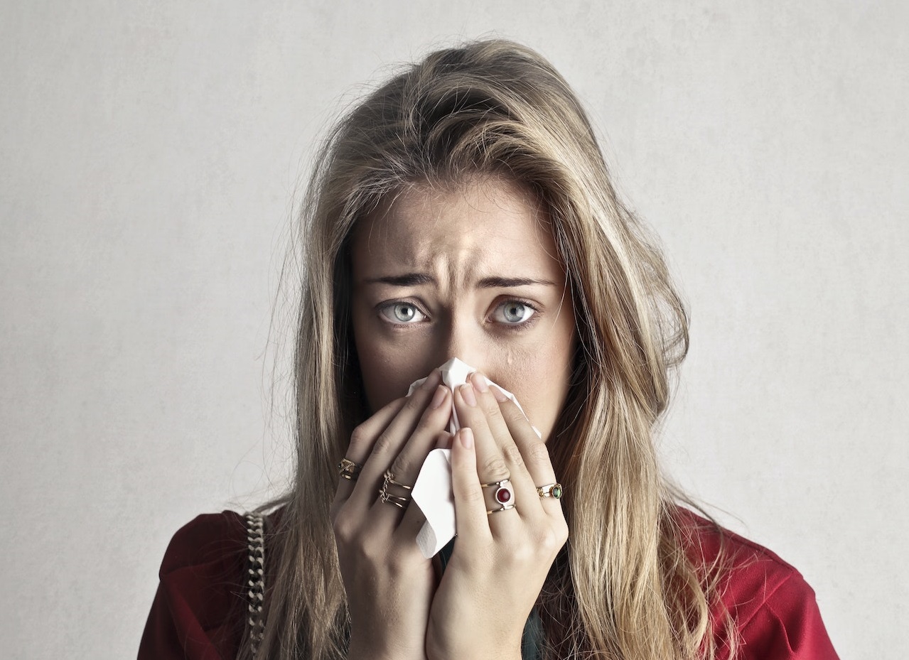 Young woman is crying and looking at camera.
