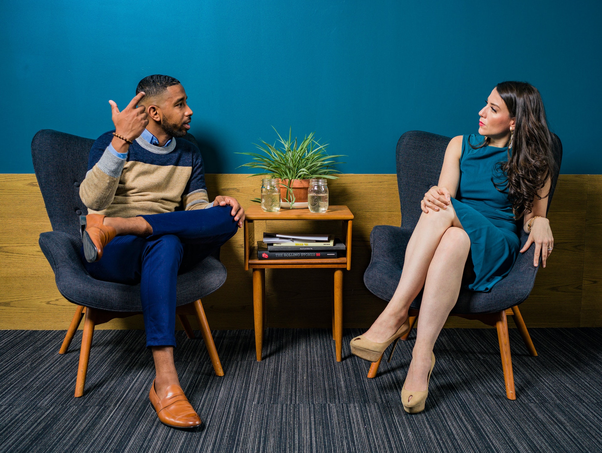 Shocked man and woman having conversation sitting on armchairs
