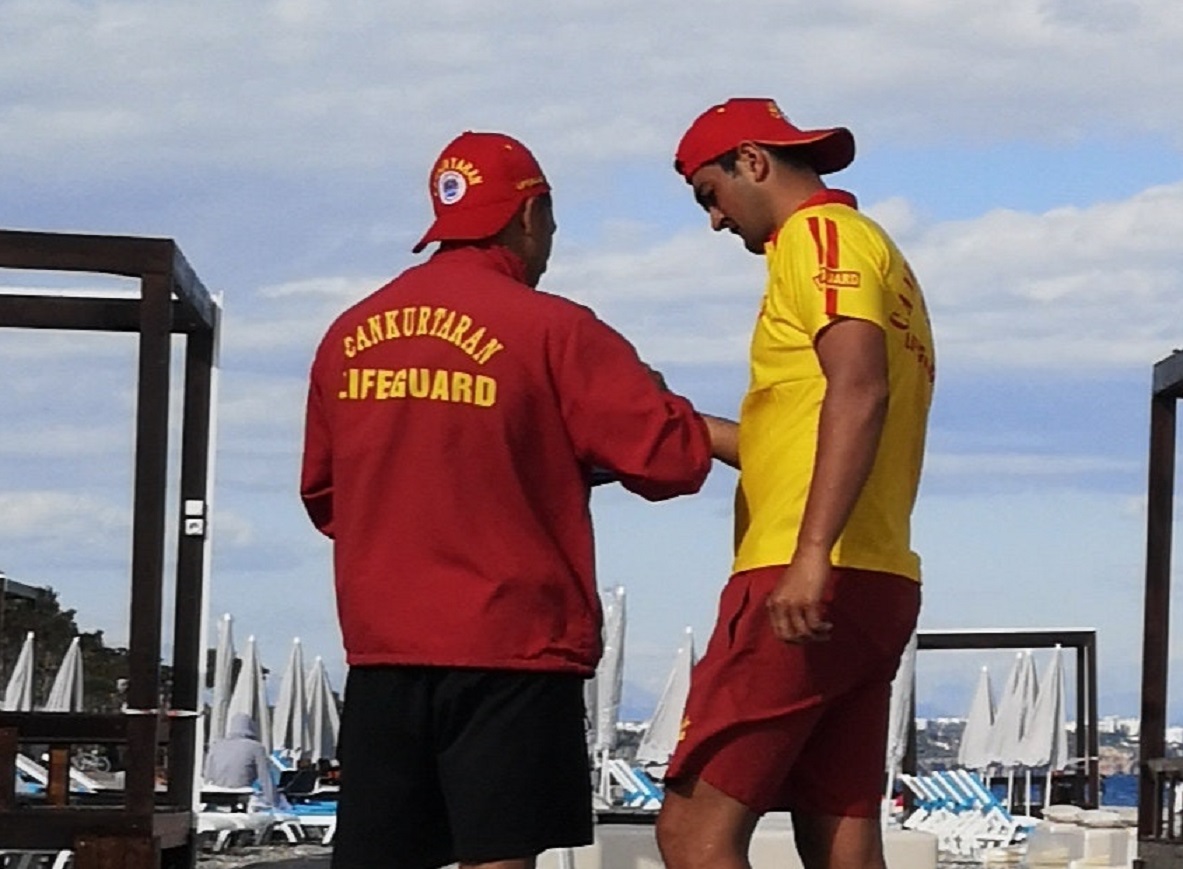 Two lifeguards on duty are talking.