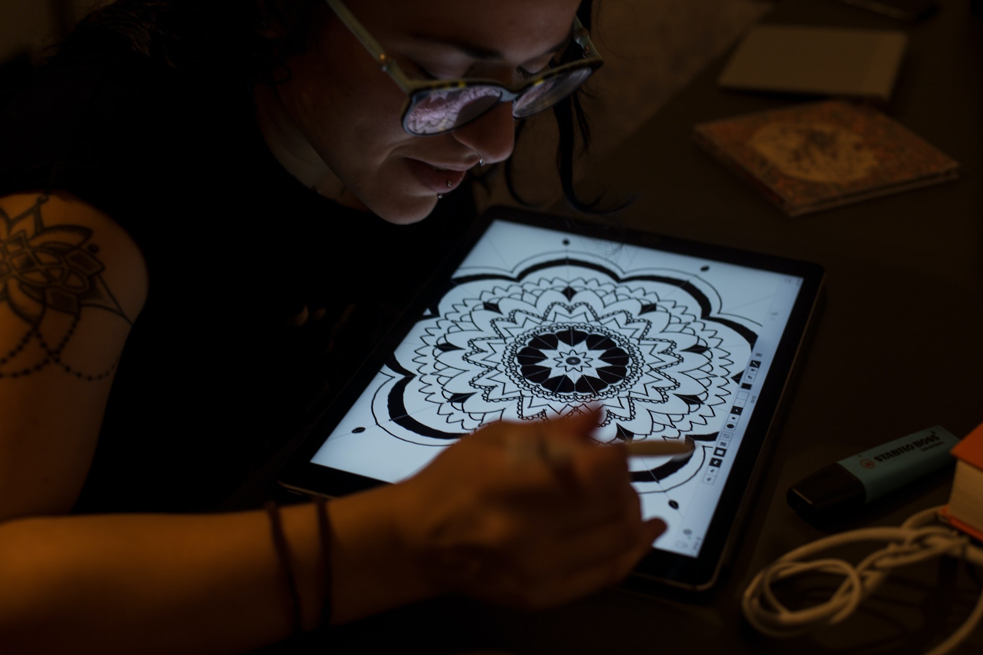 Girl tattoo artist working on a tattoo on a tablet