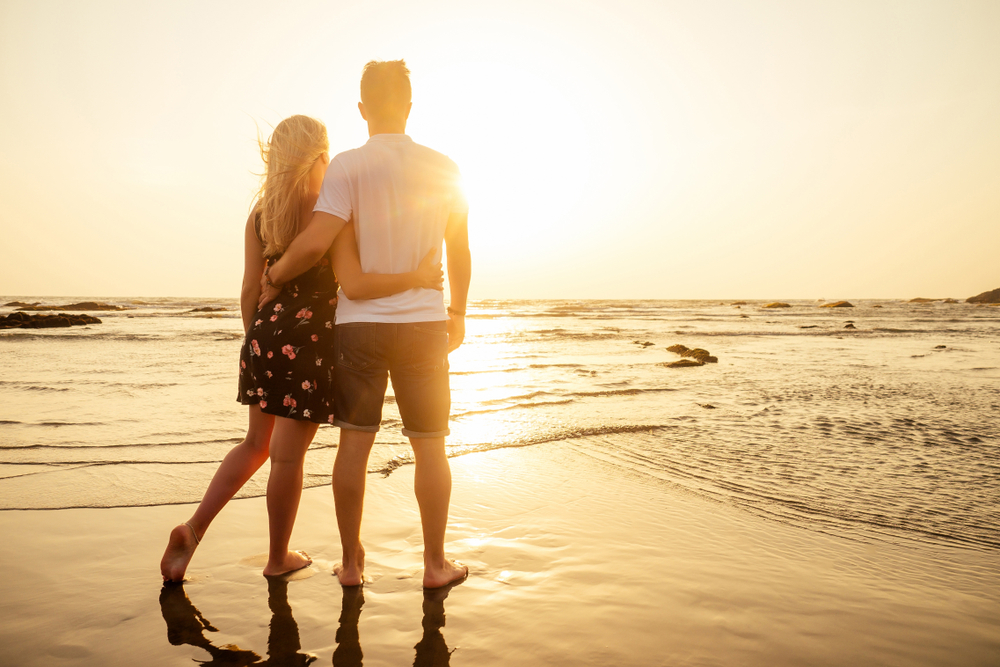 Couple at the beach looking at the sunset