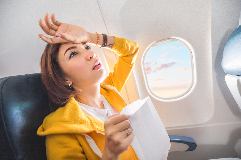 An Asian female traveler suffers from an acute attack of nausea during turbulence