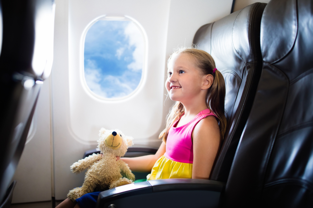 Young girl traveling by plane sitting at a seat