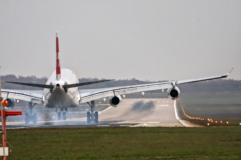 Airplane with four engines landing on runway