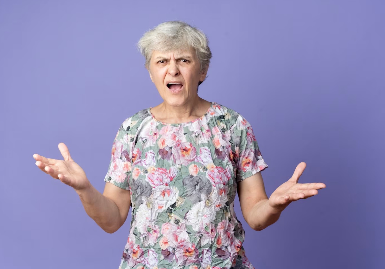 Annoyed Elderly Woman is Stands With Open Hands.