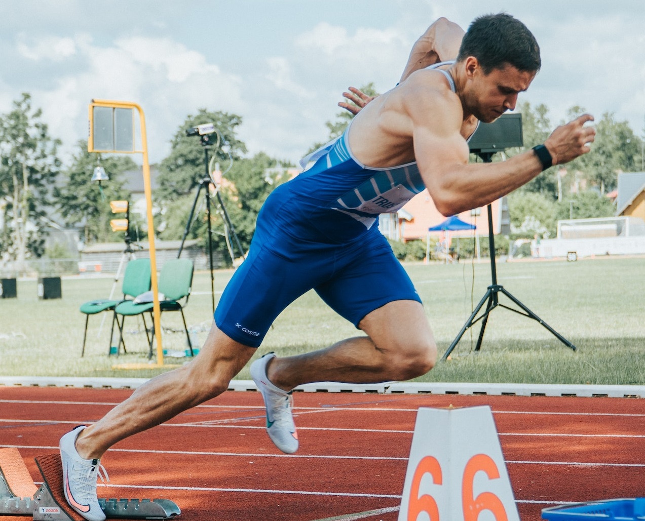 Runner wearing blue uniform and is running at start.
