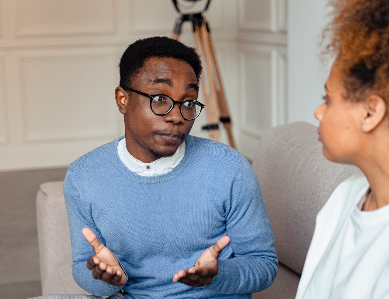 Couple is seating on the bed and arguing with each other.