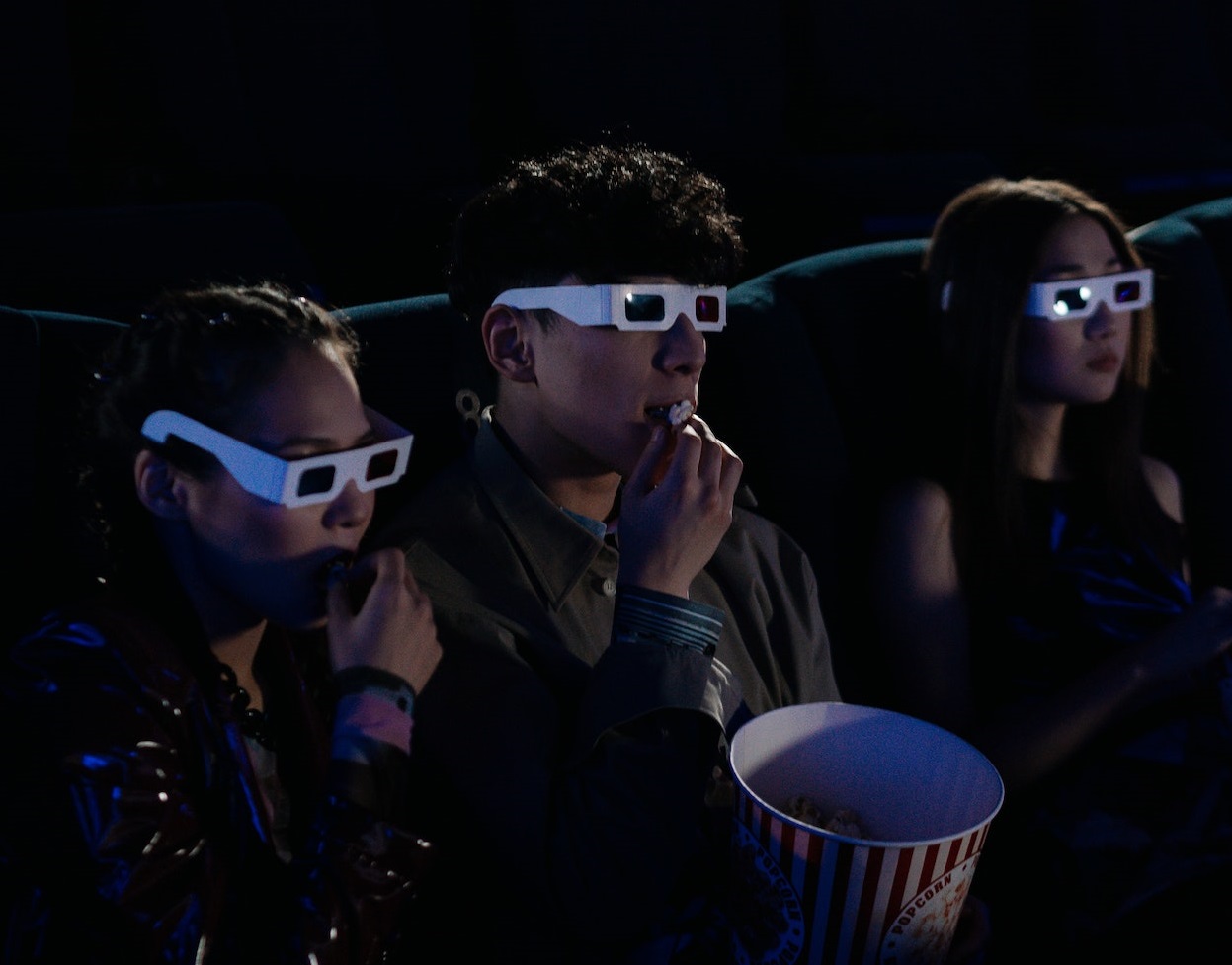 Group of friends are wearing 3d glasses and watching movie.