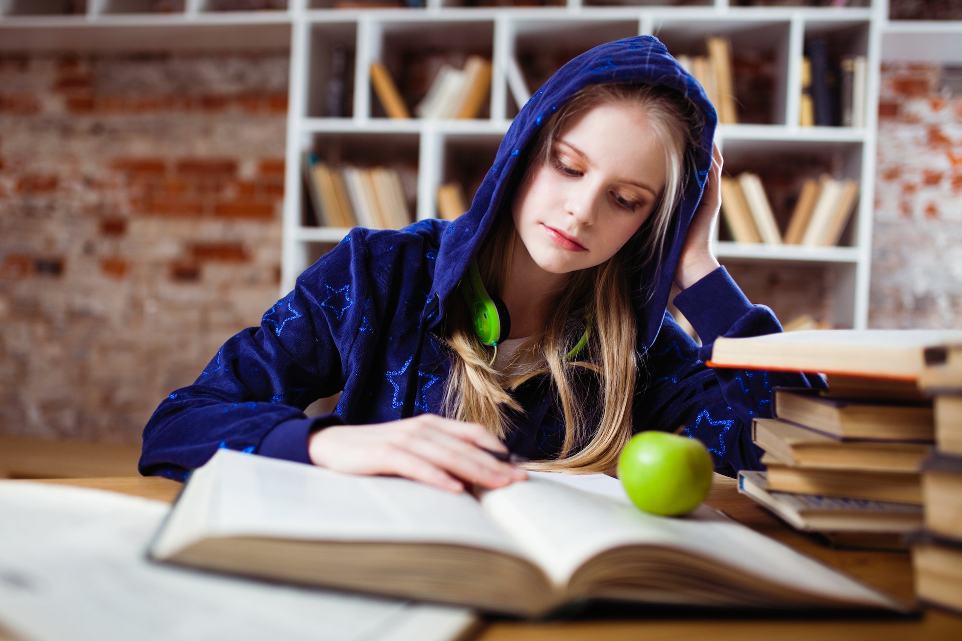 woman wearing blue sweatshirt studying