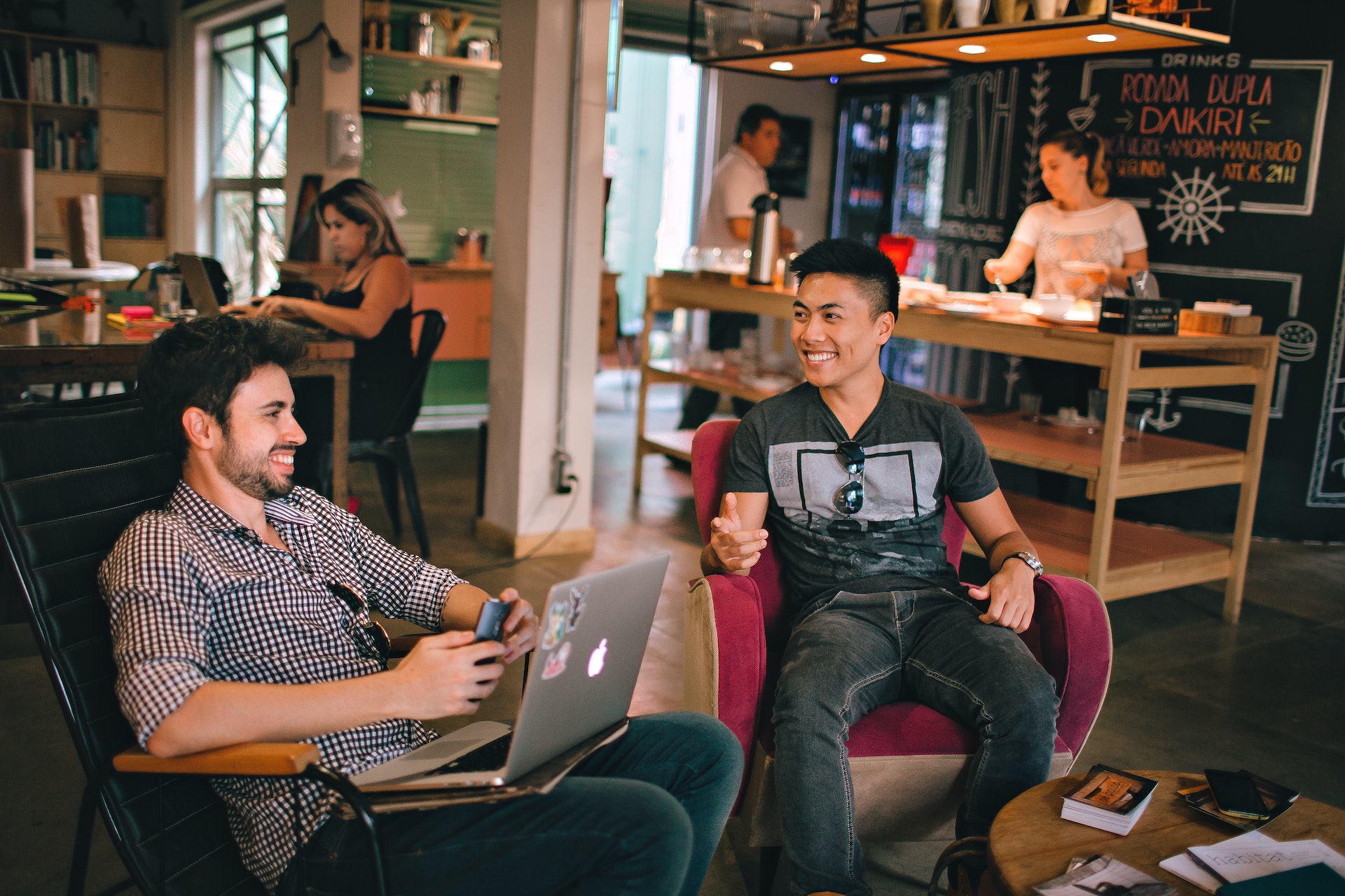 Two men are having a conversation while seating on chair.