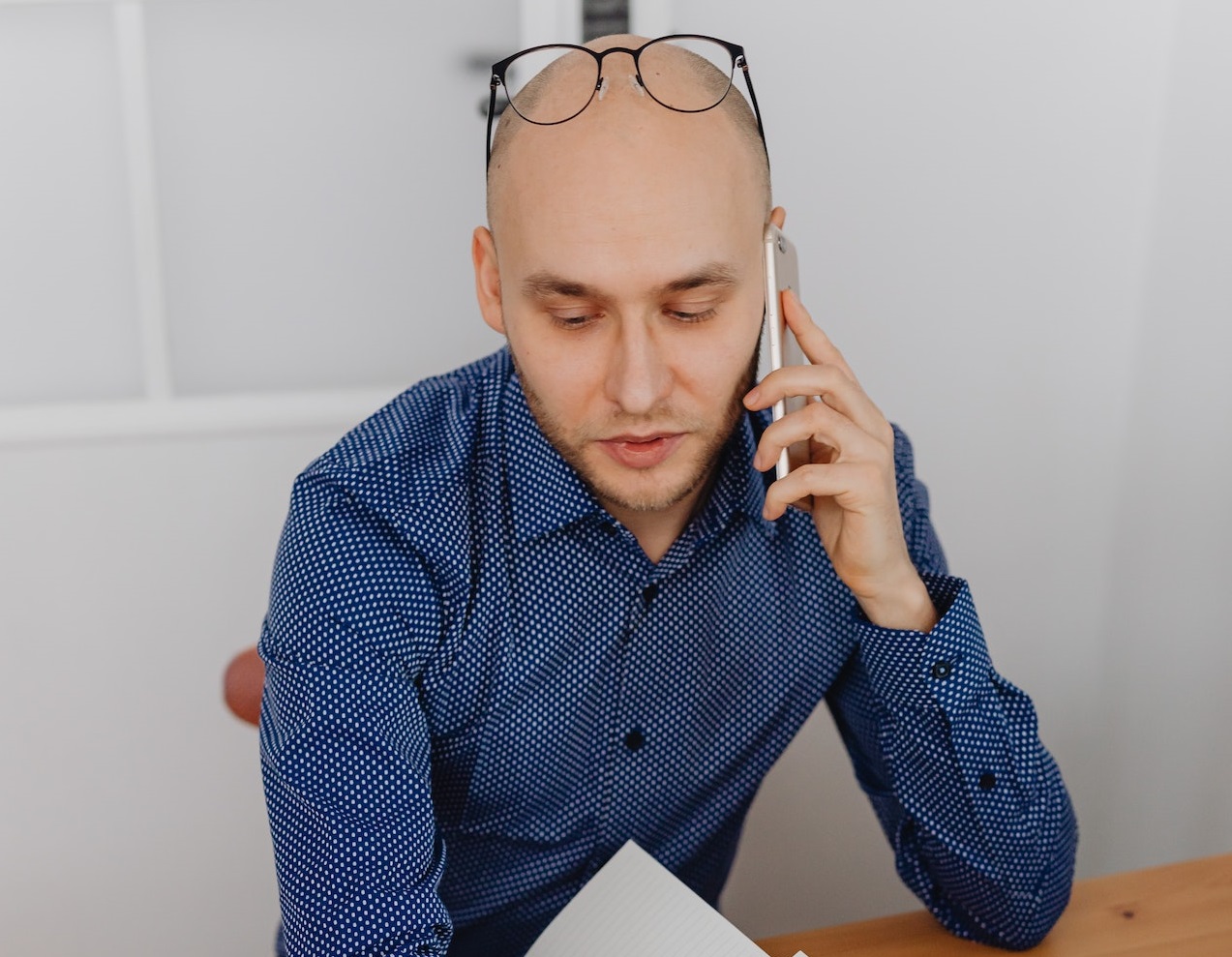 Man is talking on the phone at office.