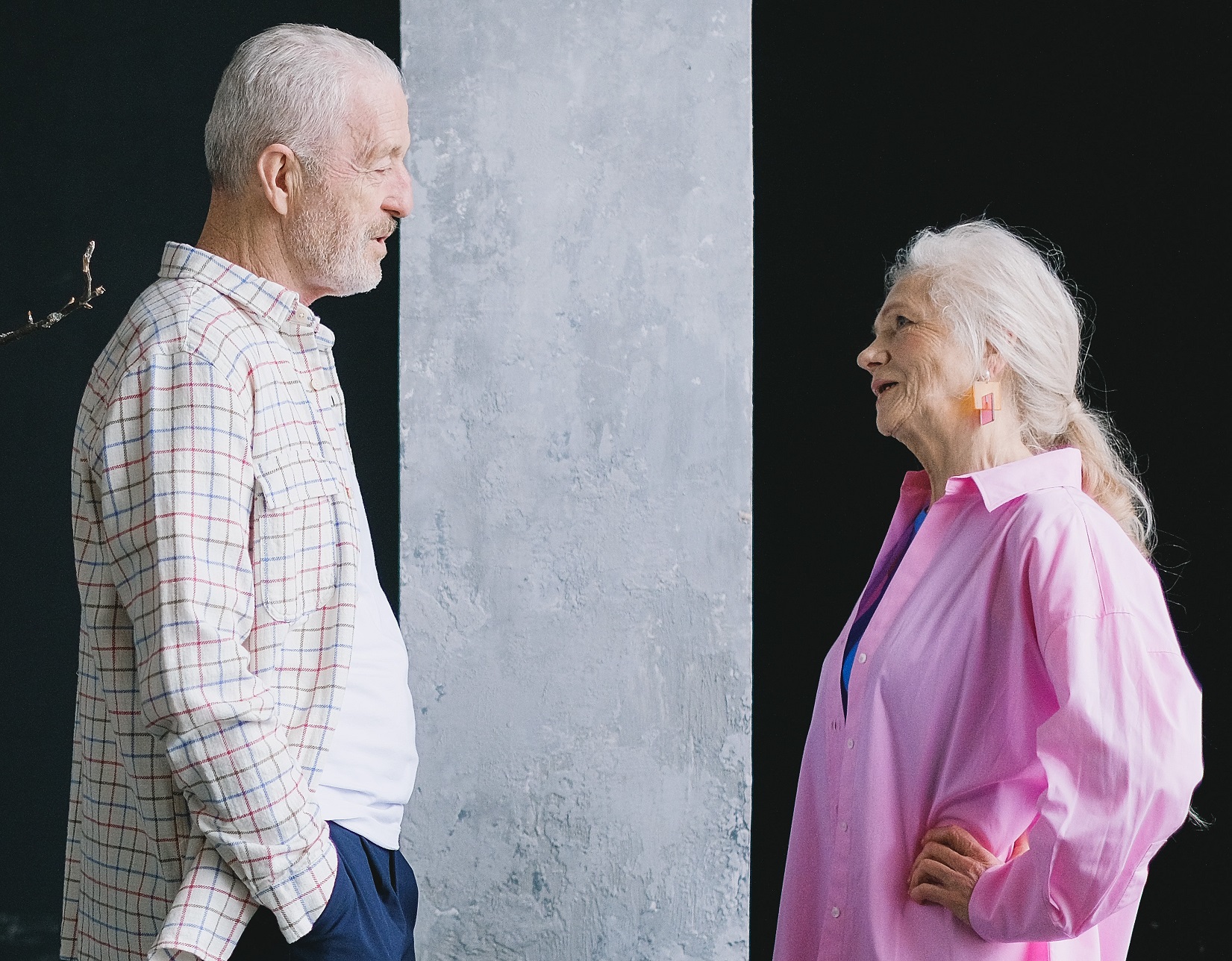 Woman is talking with a senior man holding his hands in his pockets.