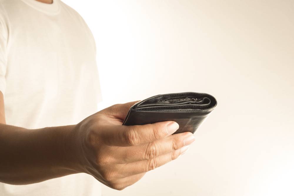 Hand holding empty old wallet