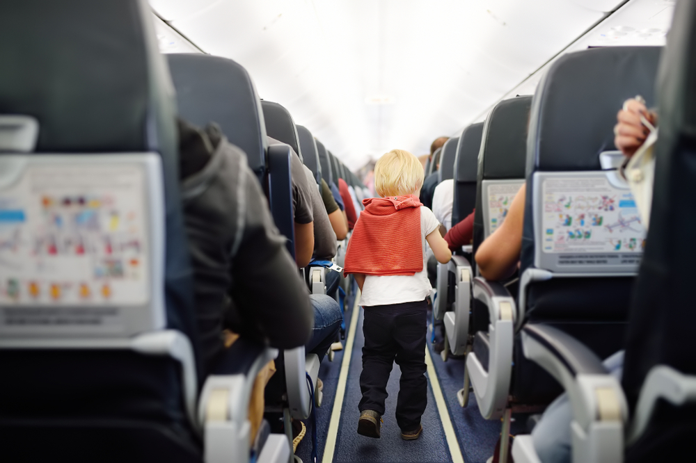 kid running on plane between seats